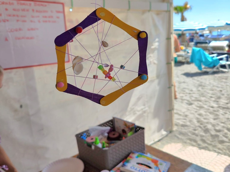 Laboratorio creativo per bambini con realizzazione di acchiappasogni colorati con stecchi di legno, conchiglie e perline, attività creativa organizzata per bambini e famiglie